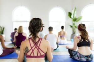 Healthy people making a Sukhasana yoga pose in yoga class