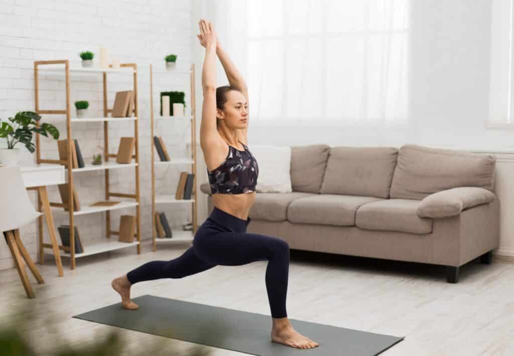Donna atletica che fa yoga, esercizio di stretching a casa